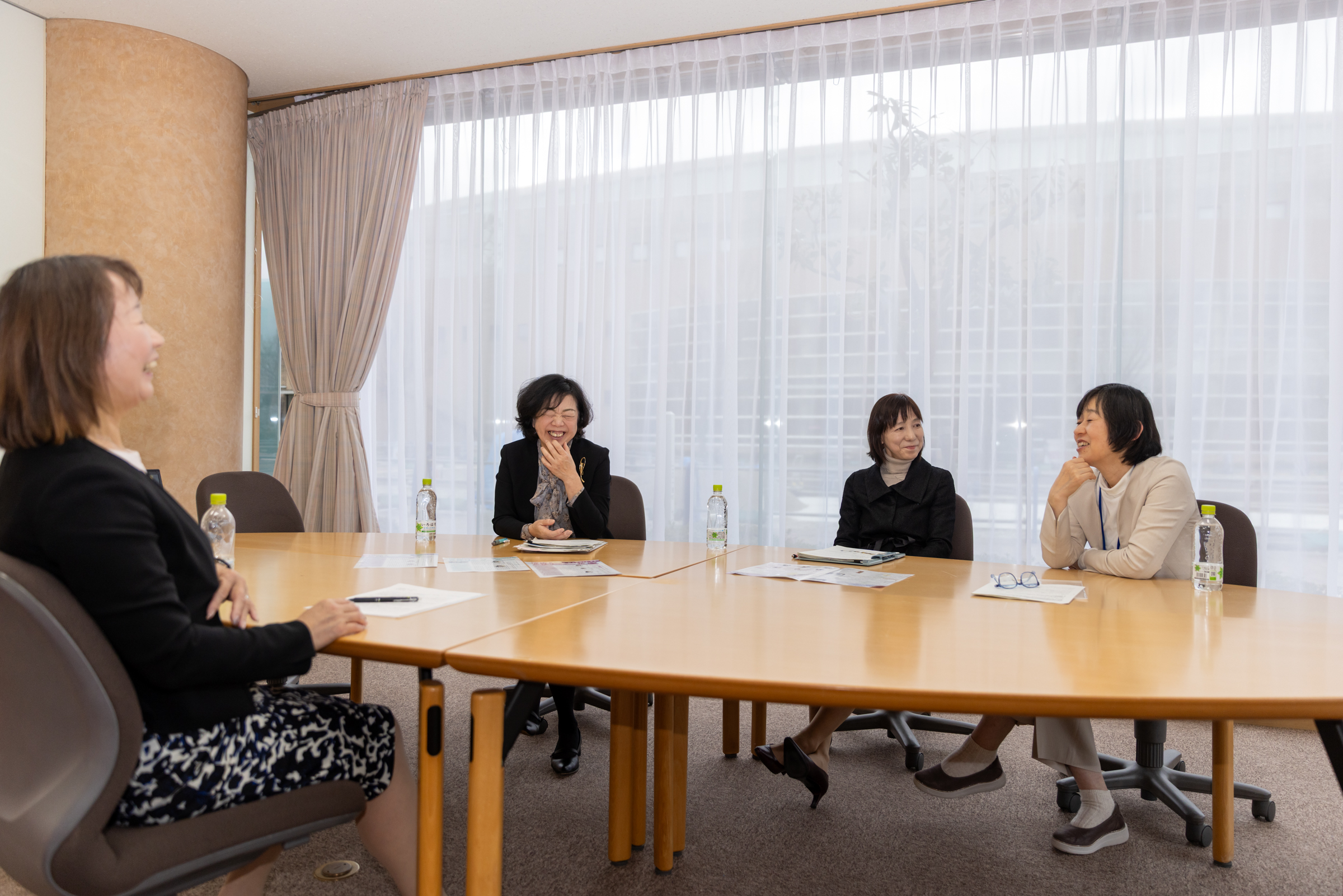 女性の上司がハイタッチして帰られたことを思い出しながら歓談する対談中の写真