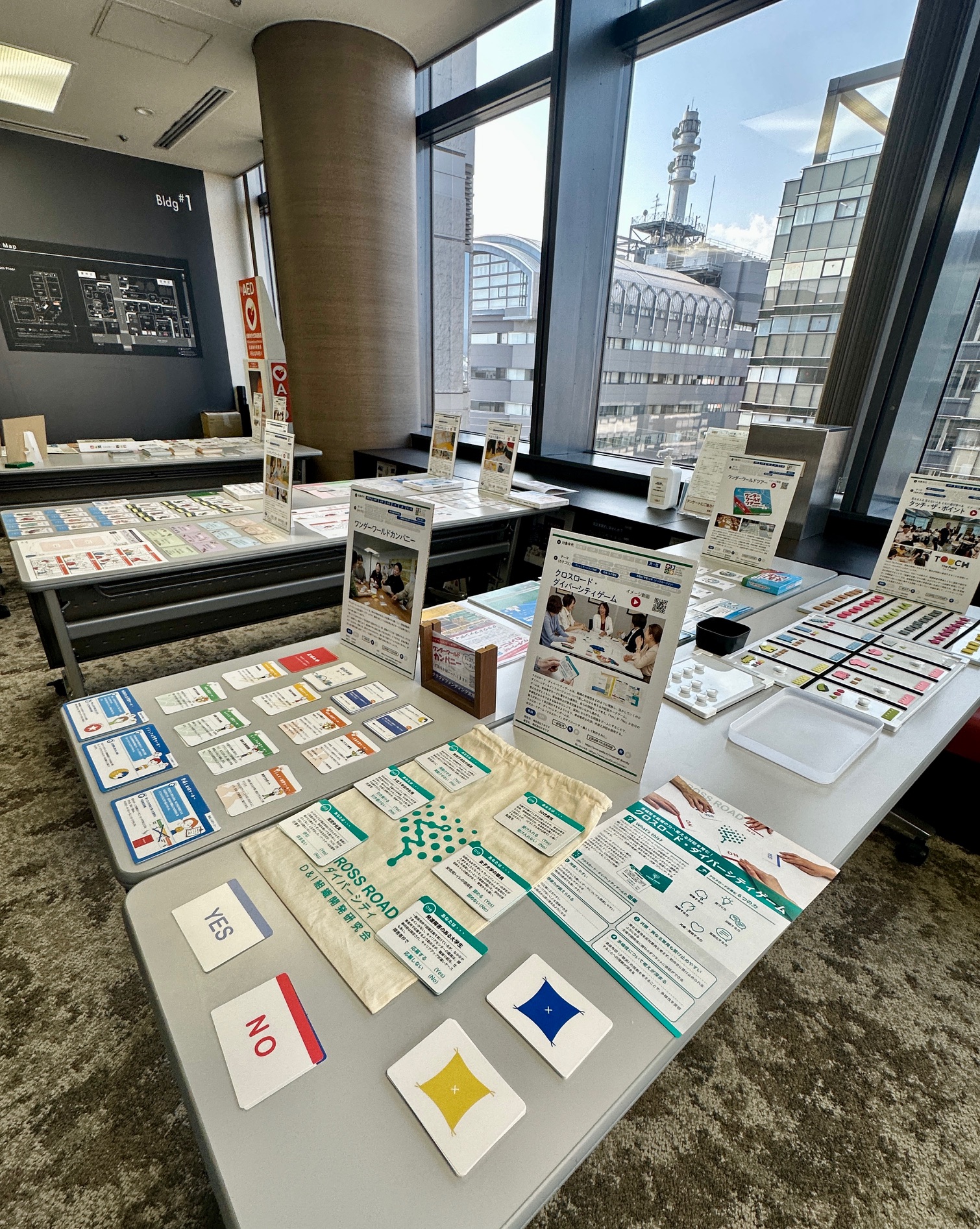 京都SDGsゲームショウに出展された、DEIコンサルティングに活用する「クロスロード・ダイバーシティゲーム」の展示ブースです。机上にはダイバーシティ研修で用いる多様な設問カードや解説パンフレットが並べられ、来場者へ専門的な学びの機会を提供しています。